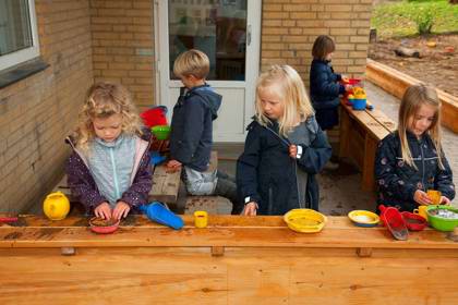 Børn leger i udendørs køkken