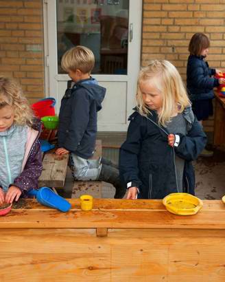 Børn leger i udendørs køkken