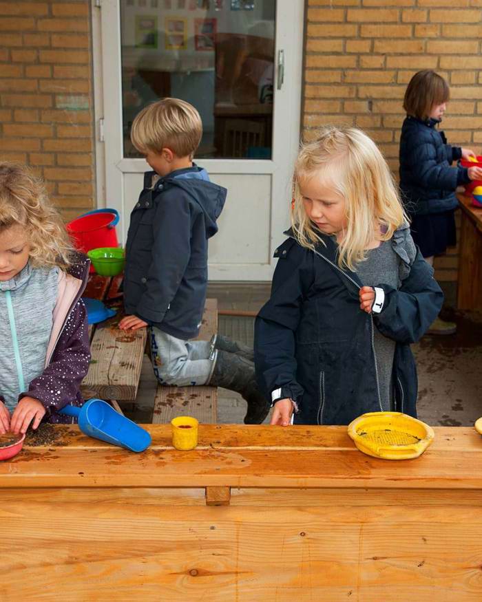 Børn leger i udendørs køkken