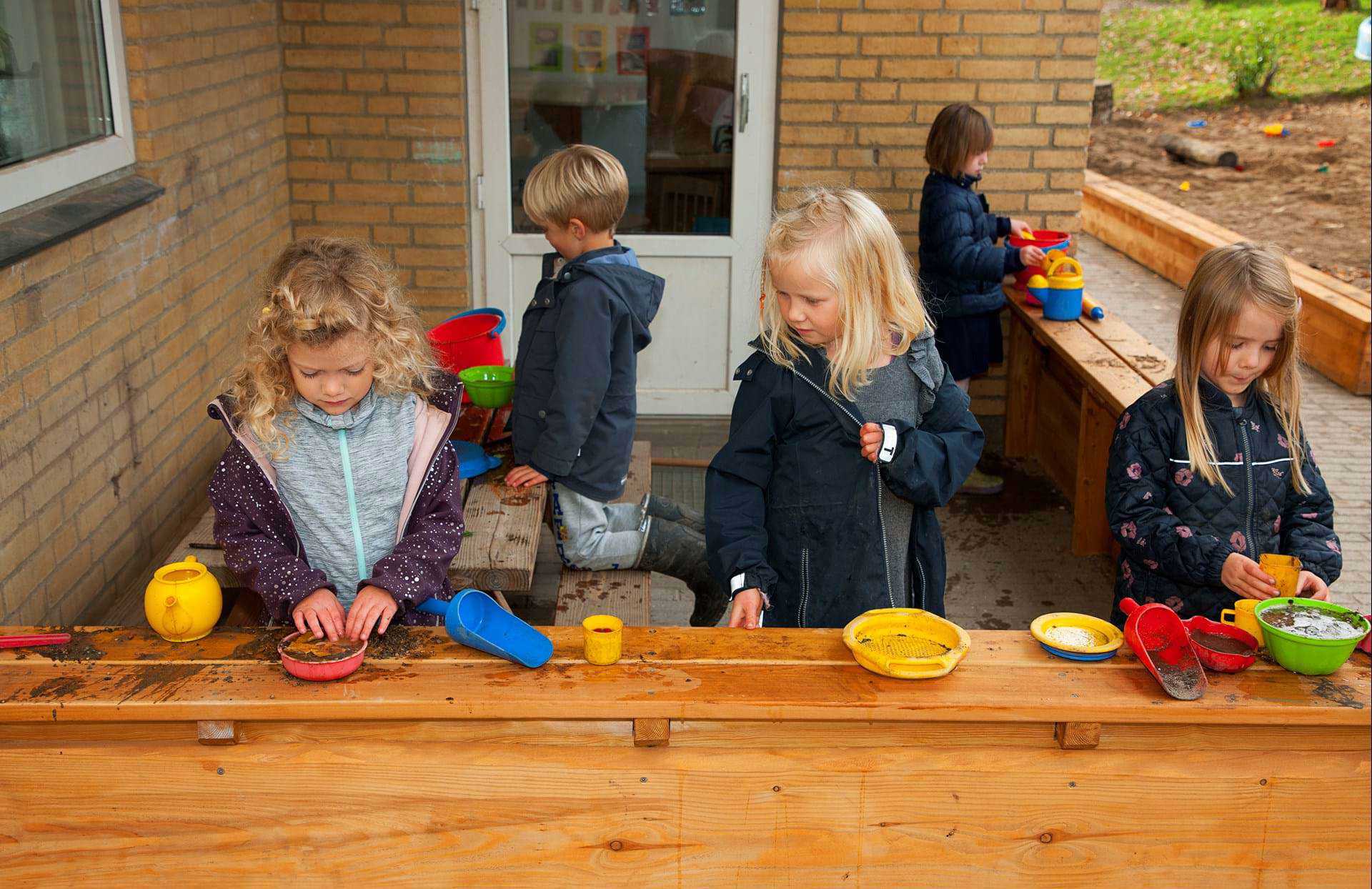 Børn leger i udendørs køkken