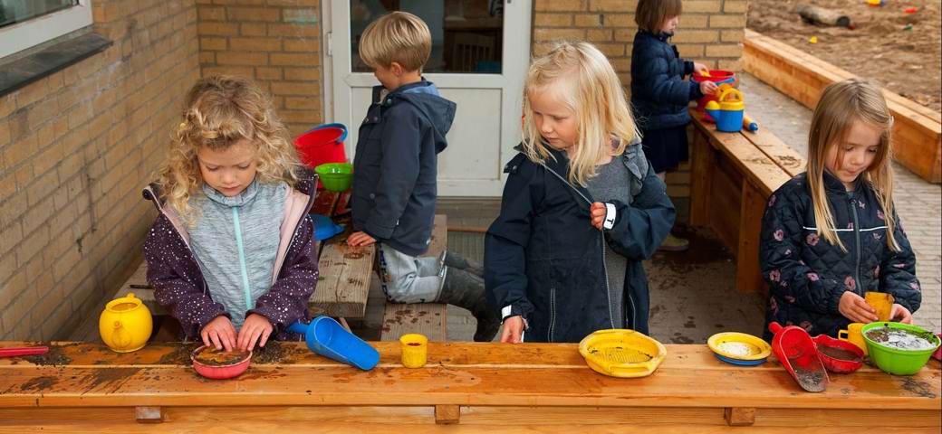 Børn leger i udendørs køkken