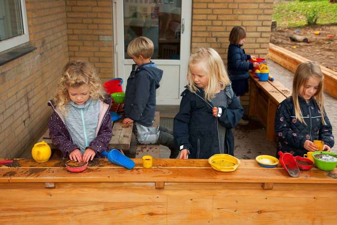 Børn leger i udendørs køkken