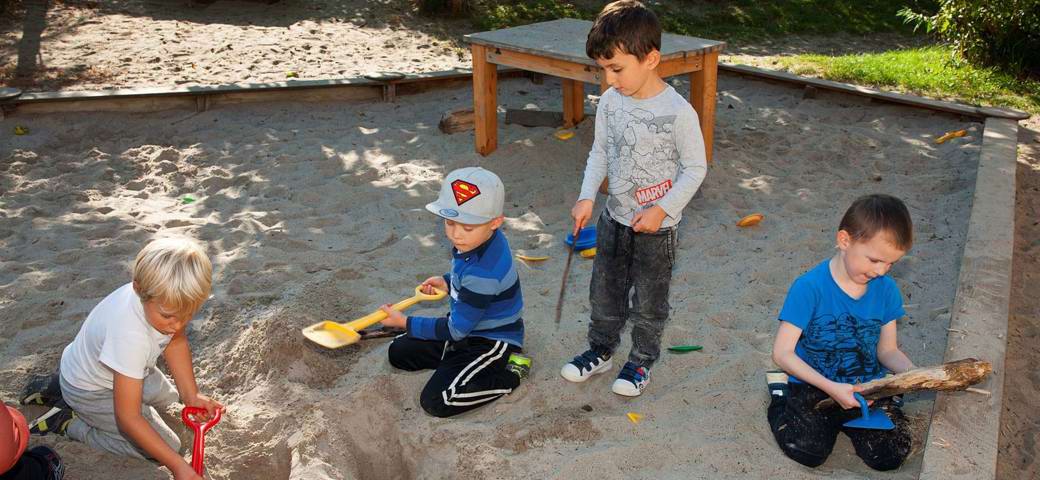 Børn leger i sandkasse