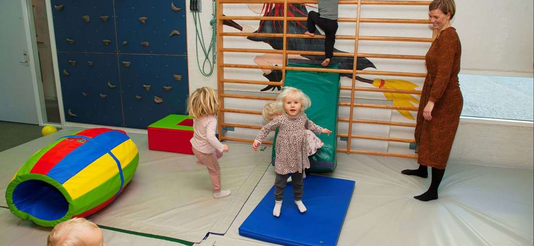 Børn kravler i ribbe i aktivitetsrum